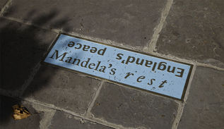 A cast iron enamelled plaque set into a stone footpath 