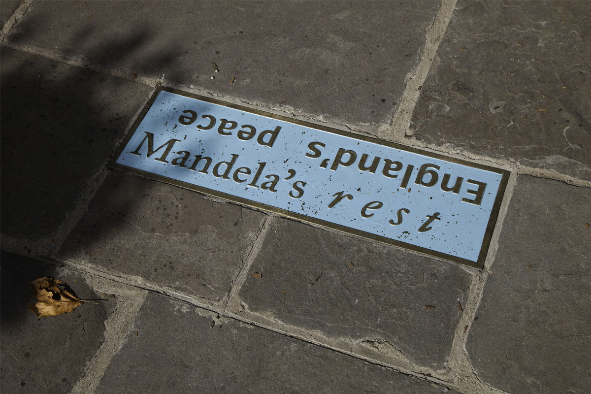 A cast iron enamelled plaque set into a stone footpath 